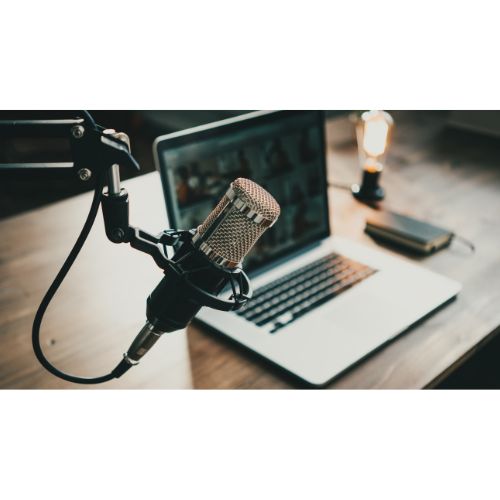 Podcast microphone set up next to a laptop